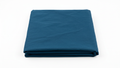 Picture of dark blue bedding, folded on a dark blue background. 