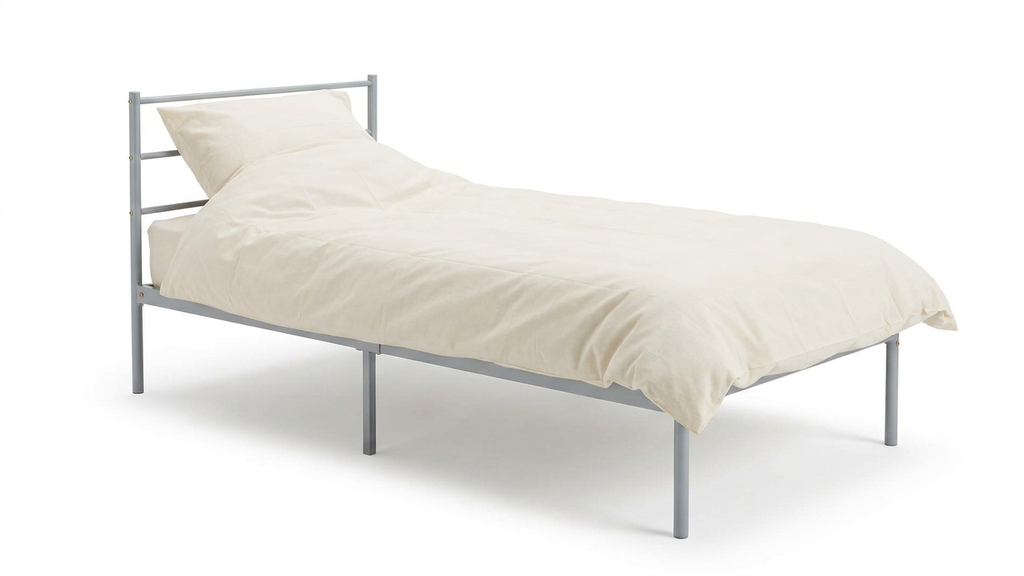 Single metal bed with mattress and cream bedding and pillow on a white background